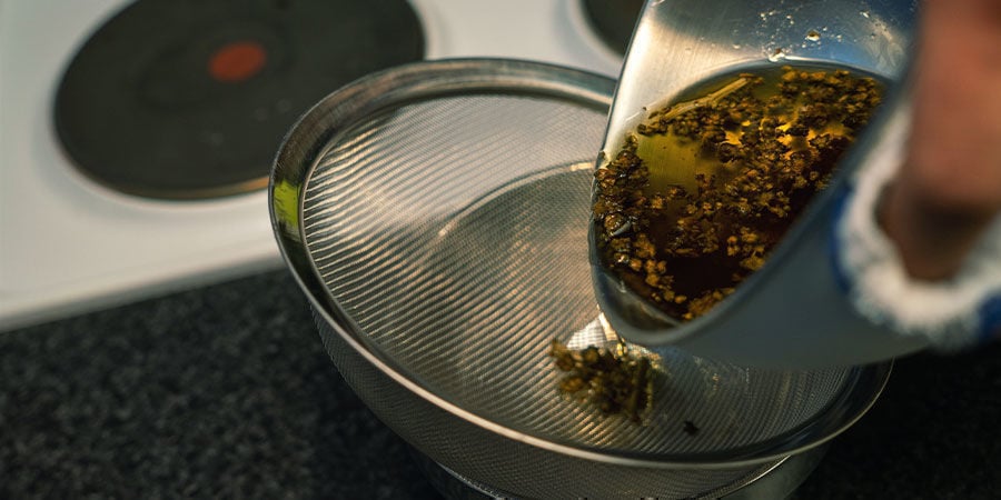 Die Cannabis-Öl-Mischung mit einem feinen Sieb abseihen