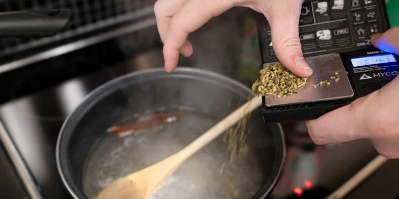 Gib das decarboxylierte Cannabis in den Topf und lass es bei niedriger Hitze für 20 Minuten köcheln.