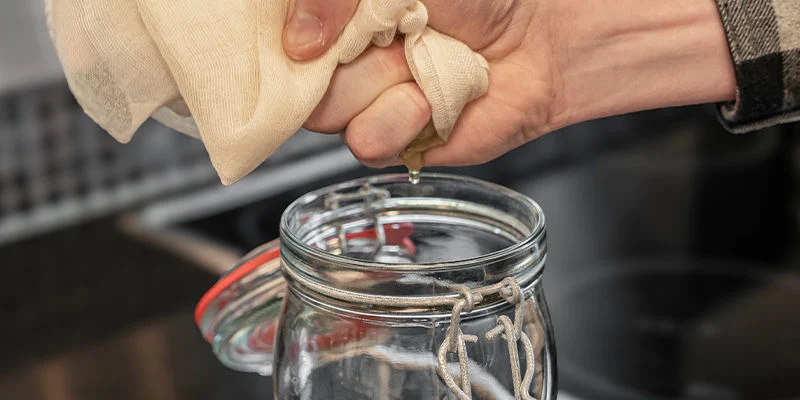 Gieße den gefilterten Sirup in eine saubere Flasche oder ein Glas.