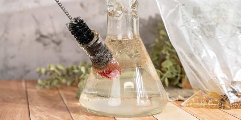 Next, take a brush and scrub the built-up grime inside and around your bong and its parts