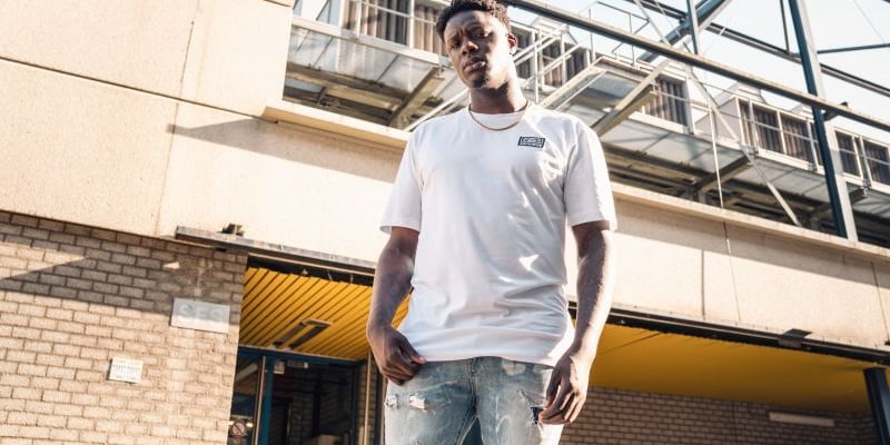 Lässig-cooles, klassisches, weißes T-Shirt mit gesticktem Logo und psychedelischem Hintergrund